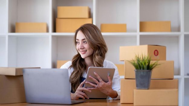 Portrait of Starting small businesses SME owners female entrepreneurs working on receipt box and check online orders to prepare to pack the boxes, sell to customers, sme business ideas online..