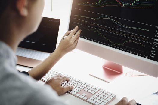 An investment expert points a pen at a tablet monitor to analyze the stock market to teach you how to make a profit