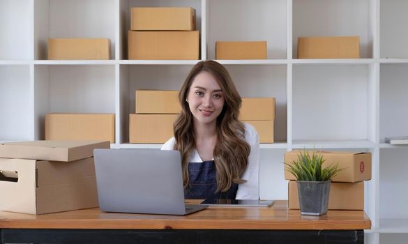 Portrait of Asian young woman SME working with a box at home the workplace.start-up small business owner, small business entrepreneur SME or freelance business online and delivery concept..