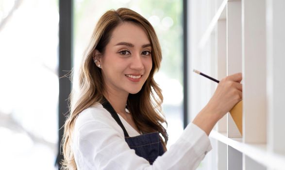 Portrait of Asian young woman SME working with a box at home the workplace.start-up small business owner, small business entrepreneur SME or freelance business online and delivery concept..