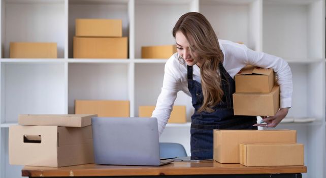 Portrait of Starting small businesses SME owners female entrepreneurs working on receipt box and check online orders to prepare to pack the boxes, sell to customers, SME business ideas online..