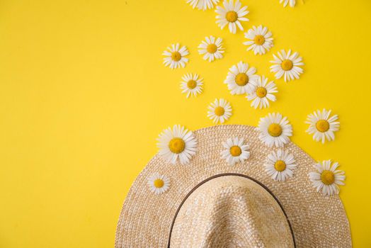 straw hat and daisies around. summer concept
