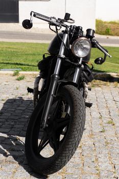 Black classic motorcycle on the city street close up