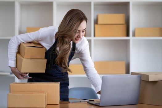 Portrait of Starting small businesses SME owners female entrepreneurs working on receipt box and check online orders to prepare to pack the boxes, sell to customers, SME business ideas online..