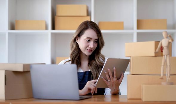 Portrait of Starting small businesses SME owners female entrepreneurs working on receipt box and check online orders to prepare to pack the boxes, sell to customers, sme business ideas online..