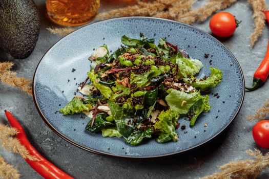 Fresh lamb lettuce salad with avocado, cucumber, salmon, cherry tomatoes. Dressing with honey, dijon mustard, olive oil and lemon juice, topped with chia seeds. Prepared by chef.