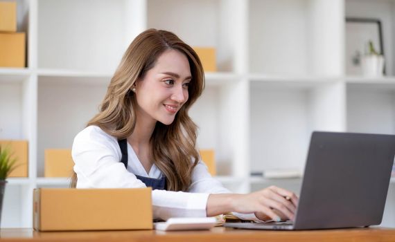 Portrait of Starting small businesses SME owners female entrepreneurs working on receipt box and check online orders to prepare to pack the boxes, sell to customers, sme business ideas online..