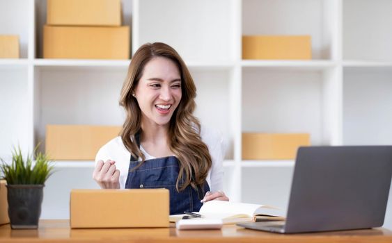 Portrait of Starting small businesses SME owners female entrepreneurs working on receipt box and check online orders to prepare to pack the boxes, sell to customers, SME business ideas online..