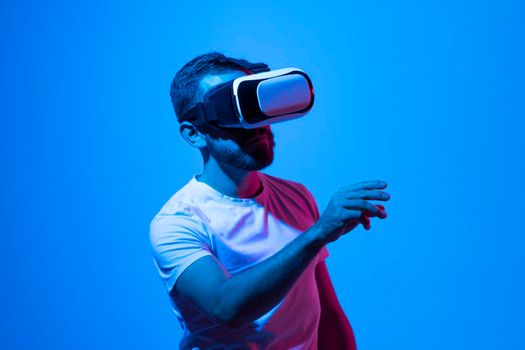 Young man close-up portrait wearing VR headset and speaking with a friends in metaverse while playing a games