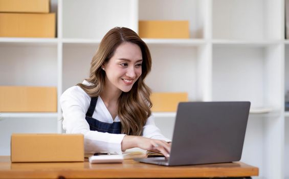 Portrait of Asian young woman SME working with a box at home the workplace.start-up small business owner, small business entrepreneur SME or freelance business online and delivery concept..