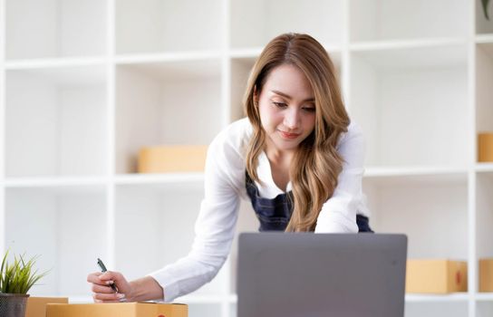 Portrait of Starting small businesses SME owners female entrepreneurs working on receipt box and check online orders to prepare to pack the boxes, sell to customers, sme business ideas online..