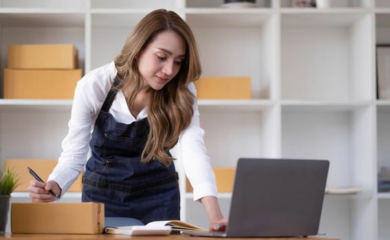 Portrait of Starting small businesses SME owners female entrepreneurs working on receipt box and check online orders to prepare to pack the boxes, sell to customers, sme business ideas online..