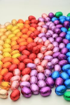 a group of foil wrapped chocolate easter eggs in rainbow colors