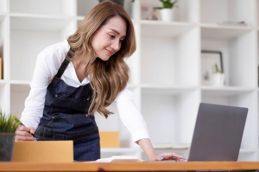 Portrait of Starting small businesses SME owners female entrepreneurs working on receipt box and check online orders to prepare to pack the boxes, sell to customers, sme business ideas online..