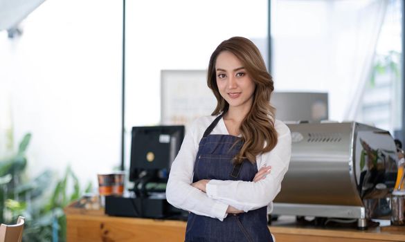 Startup successful small business owner sme beauty girl stand with tablet smartphone in coffee shop restaurant. Portrait of asian tan woman barista cafe owner. SME entrepreneur seller business concept.