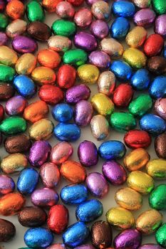 Big pile of colorful wrapped chocolate easter eggs