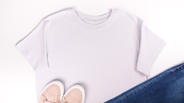 Light grey unisex t shirt mock up flat lay on white background. Top front view t-shirt, snikers, jeans and copy space. Mockup t-shirt and summertime. Template blank shirt