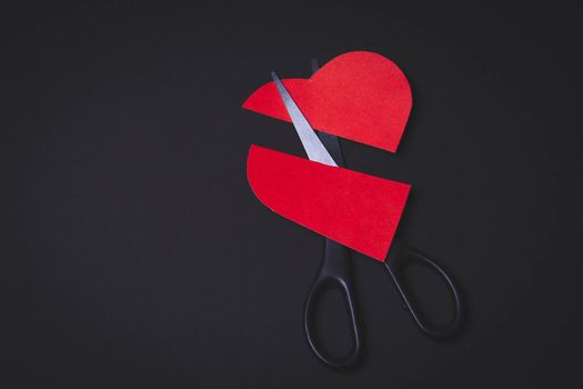 Broken heart. Divorce of a married couple. Broken marriage. Heart in hand and scissors.