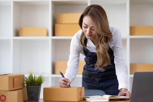 Portrait of Starting small businesses SME owners female entrepreneurs working on receipt box and check online orders to prepare to pack the boxes, sell to customers, sme business ideas online..