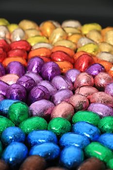 a group of foil wrapped chocolate easter eggs in rainbow colors