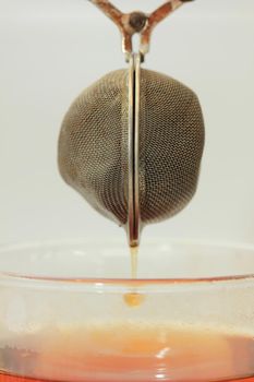 Metal tea infuser with tea dripping out