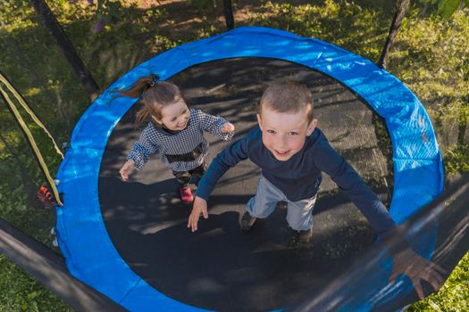 top view of small children jumping on a trampoline