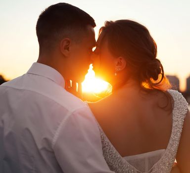 A kiss of the bride and groom at sunset. Wedding article. A happy couple. Love. Photos for printed products. Romance