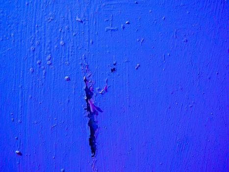 Big scratch on the wall with blue paint.Abstract surface from damaged old blue paint.
