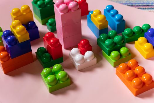 Colorful plastic construction blocks on white background as kids toys frame