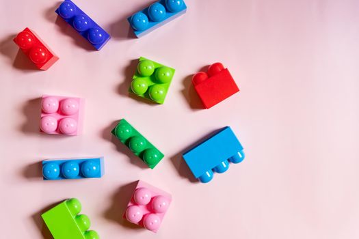 Colorful plastic building blocks flat lay. Yellow background. Child developing game. Pattern