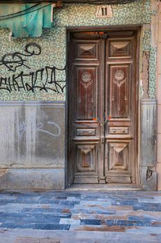 Cartagena, Murcia, Spain- July 18, 2022: Old wooden door with carved details on facade under restoration in Cartagena