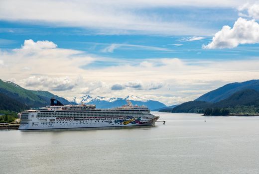 Juneau, AK - 9 June 2022: View of the port of Juneau in Alaska with Norwegian Jewel cruise ship anchored in the bay