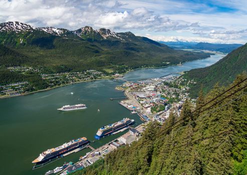 Juneau, AK - 9 June 2022: Overhead view of three cruise ships in port of Juneau with Viking Orion anchored in the bay.