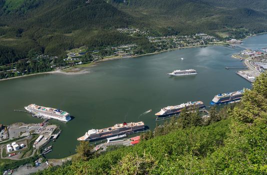 Juneau, AK - 9 June 2022: Overhead view of five cruise ships in port of Juneau with Viking Orion anchored in the bay.