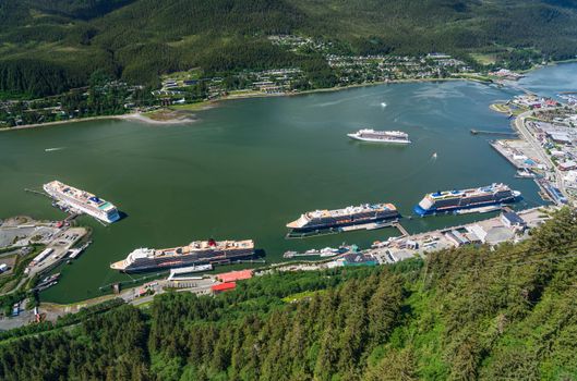 Juneau, AK - 9 June 2022: Overhead view of five cruise ships in port of Juneau with Viking Orion anchored in the bay.