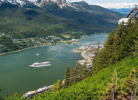 View of the port of Juneau in Alaska with cruise ships docked and anchored in the bay as seen from Mt Roberts
