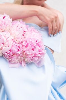 bride in a blue wedding dress with a bouquet of pink peonies, pastel paradise, floral background, complementary color combination. High quality photo