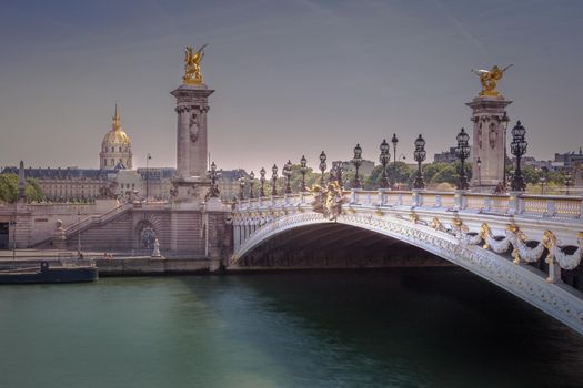 Line of Street lights and Invalides dome in Pont Alexandre III, Paris, france