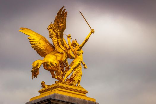 Golden fame Sculpture in Pont Alexandre III at cloudy day, Paris, france