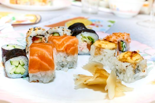 a Japanese dish consisting of small balls or rolls of vinegar-flavored cold cooked rice served with a garnish of raw fish, vegetables, or egg.Varied set of delicious oriental sushi lounge close up