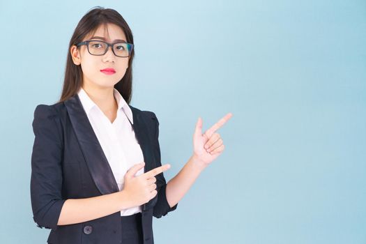 Young Asain women in suit standing using her digital tablet against blue background