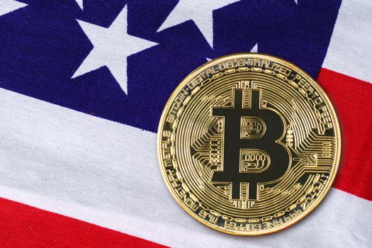 Close up Crypto currency concept. Gold Bitcoin coin on flag of United States of America USA