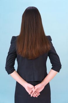 Asian women wearing a suit in studio from behind agent blue background