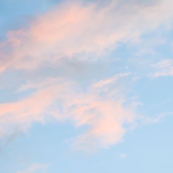 Background of blue sky with pale pink clouds at sunset