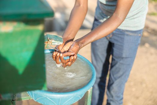 Top view of male farm worker washing his hands after work at washing station in Africa