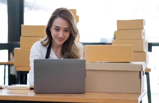 Portrait of Starting small businesses SME owners female entrepreneurs working on receipt box and check online orders to prepare to pack the boxes, sell to customers, sme business ideas online..