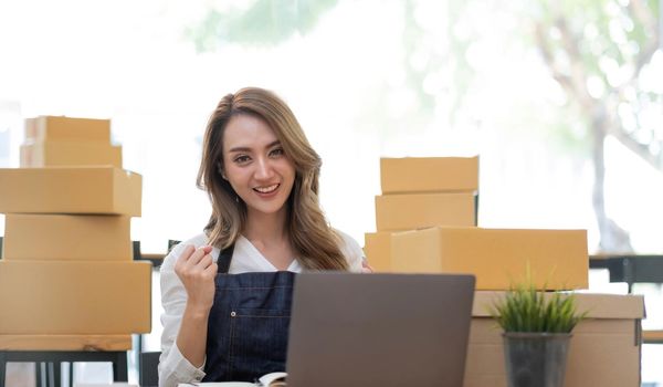 Portrait of Starting small businesses SME owners female entrepreneurs working on receipt box and check online orders to prepare to pack the boxes, sell to customers, SME business ideas online..