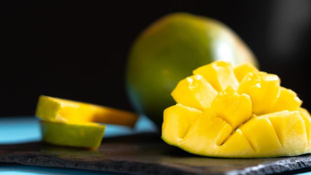 Mango cut on a dark background. Mango in home conditions not neatly cut.