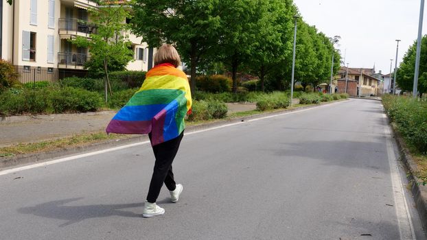 Bisexual, lesbian, woman, female, transgender walk back with LGBTQIA flag, rainbow peace in pride mounts on the road on a day and celebrate Bisexuality Day or National Coming Out Day