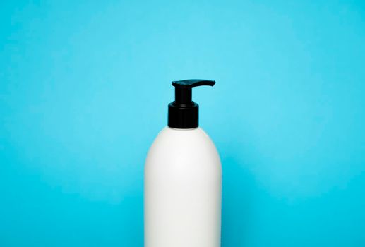 White plastic soap dispenser pump bottle isolated on blue background. Skin care lotion. Bathing essential product. Shampoo bottle. Bath and body lotion. Fine liquid hand wash. Bathroom accessories